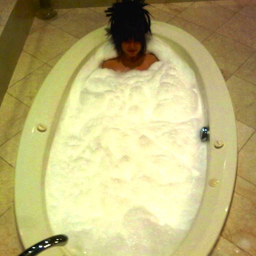 Big hair lady relax in big bath